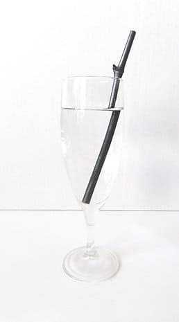 verre avec une brindille de charbon à l'intérieur