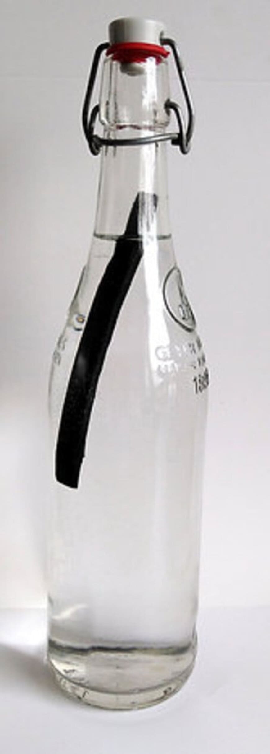 bouteille en verre remplie d'eau avec baton de charbon à l'intérieur