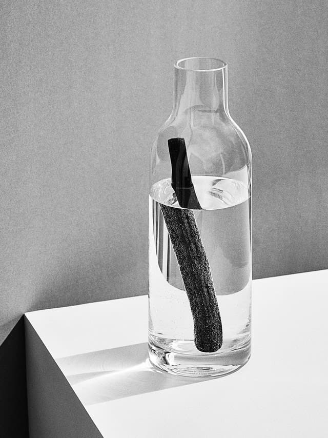 baton de charbon dans une bouteille en verre remplie d'eau